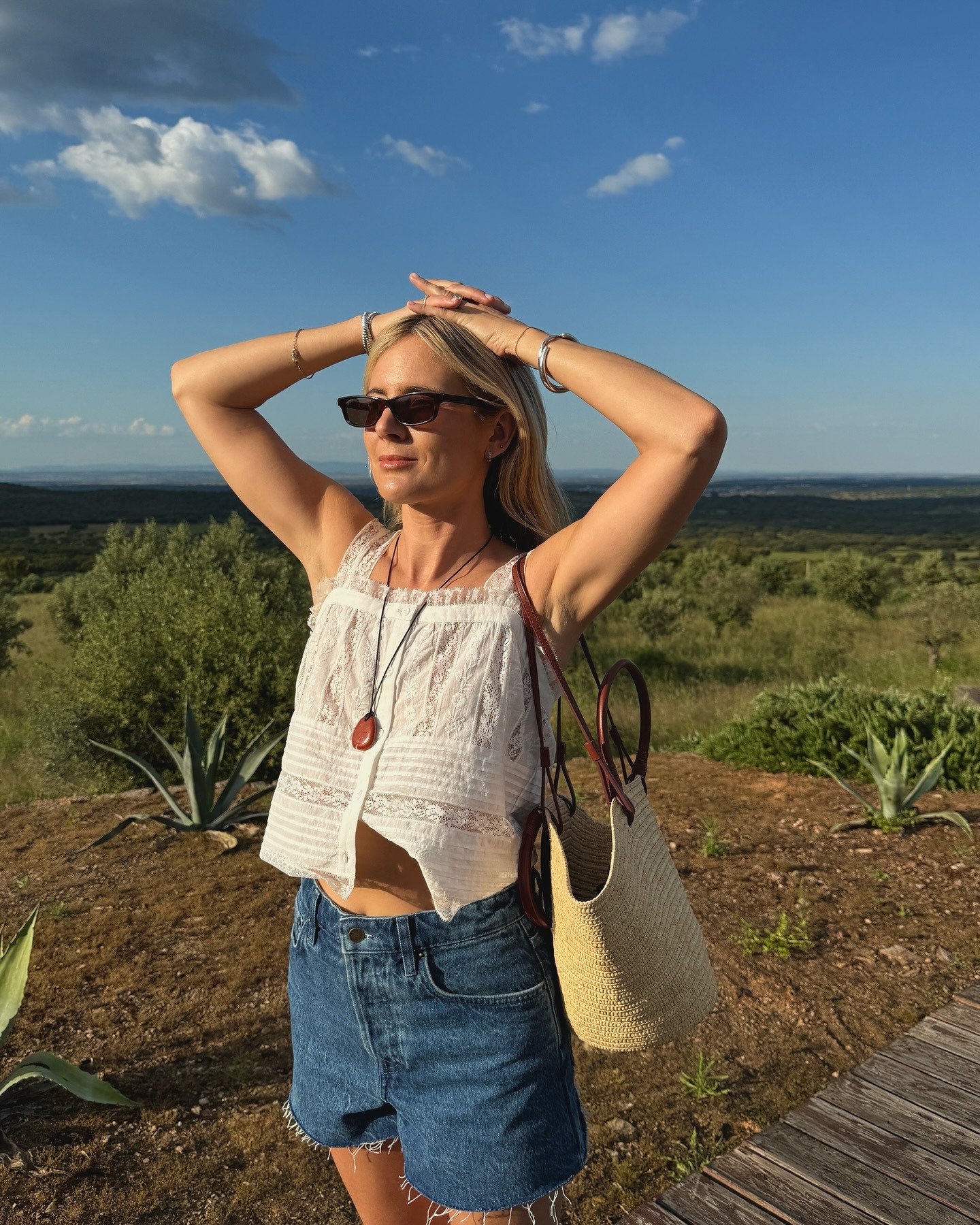 Influencer wearing a white top and denim shorts