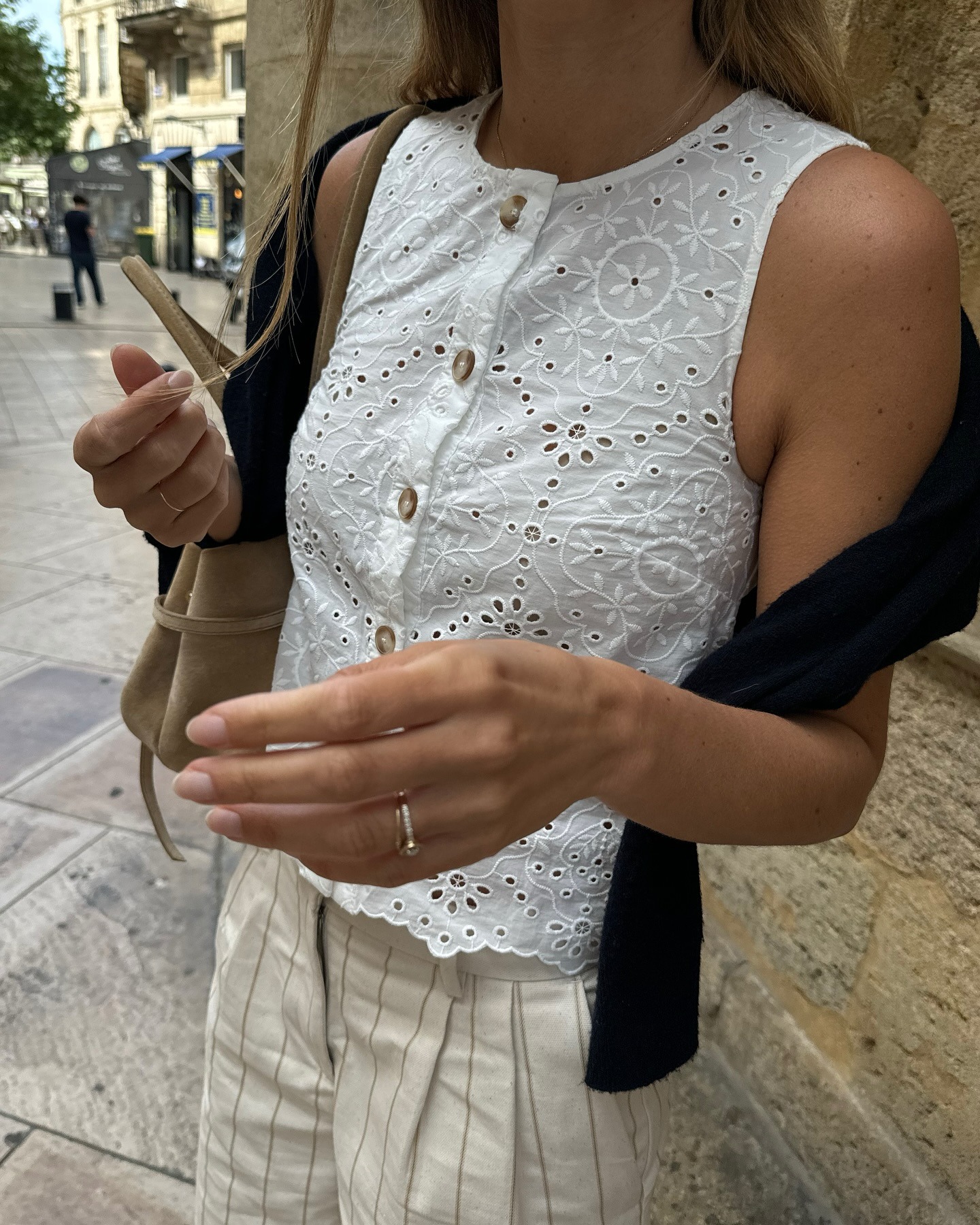 Influencer wearing a white eyelet top and striped pants