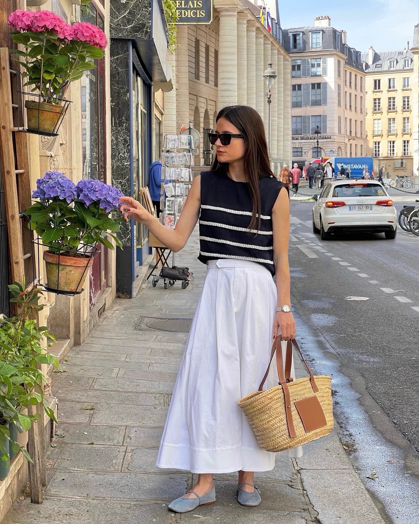 Influencer wearing a striped sweater tank and long white skirt
