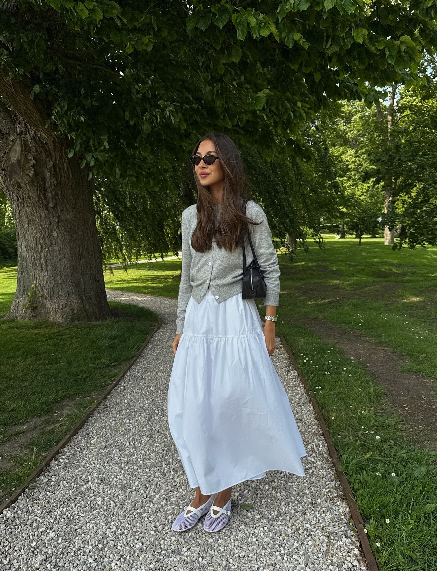 Influencer wearing a white midi skirt with a cardigan