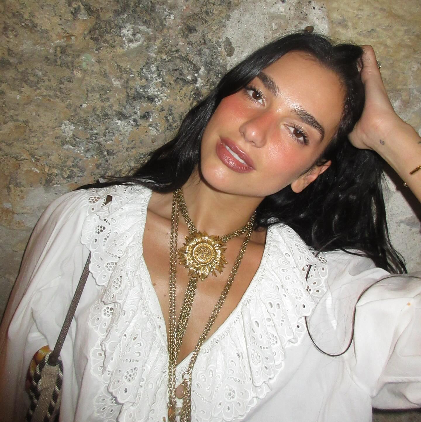 Dua Lipa wearing a pretty white shirt and denim shorts on vacation in Palermo, Italy