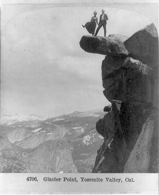 A black and white photo of people at Glacier Point in Yosemite