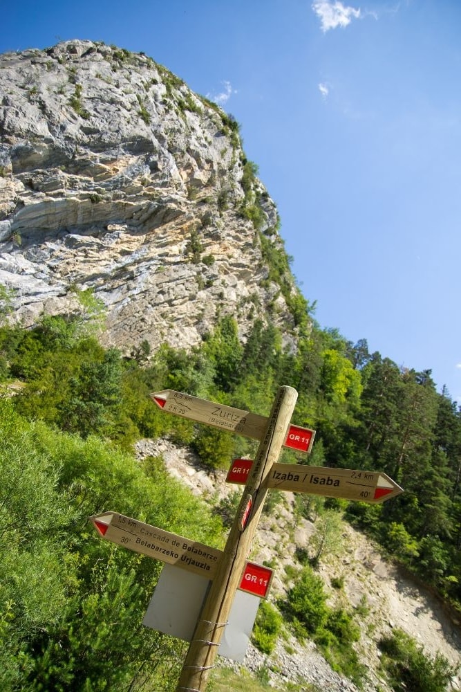 A trail sign and high mountain on the GR11 – one of the hardest long-distance treks in Europe