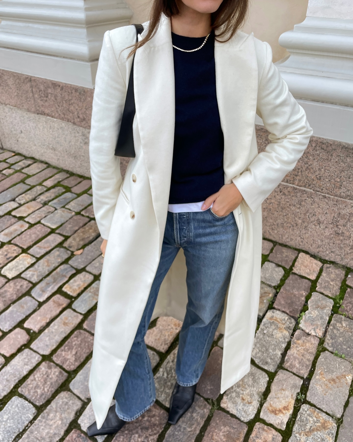 @johannapiispa wears a cream frock coat with blue jeans and a tennis necklace