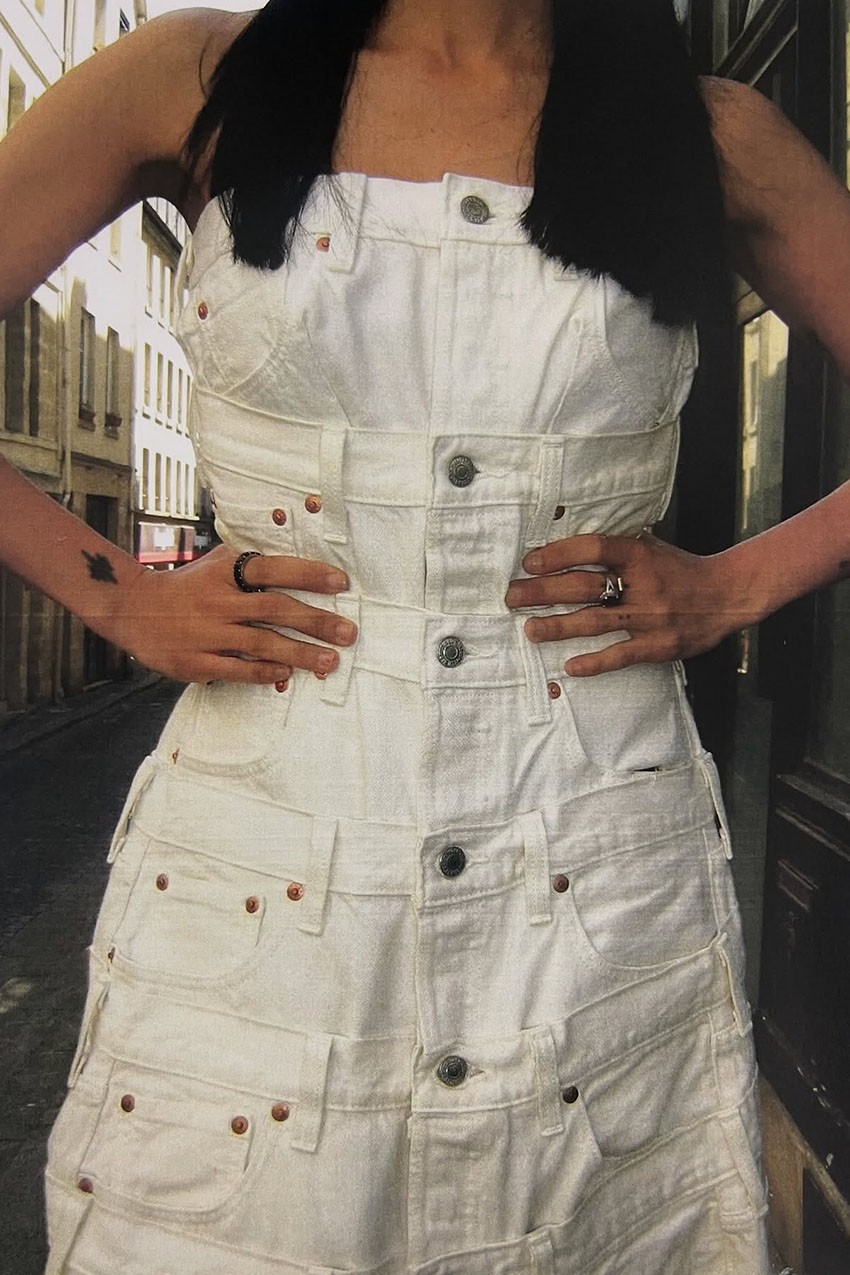 A woman wearing a white denim dress.