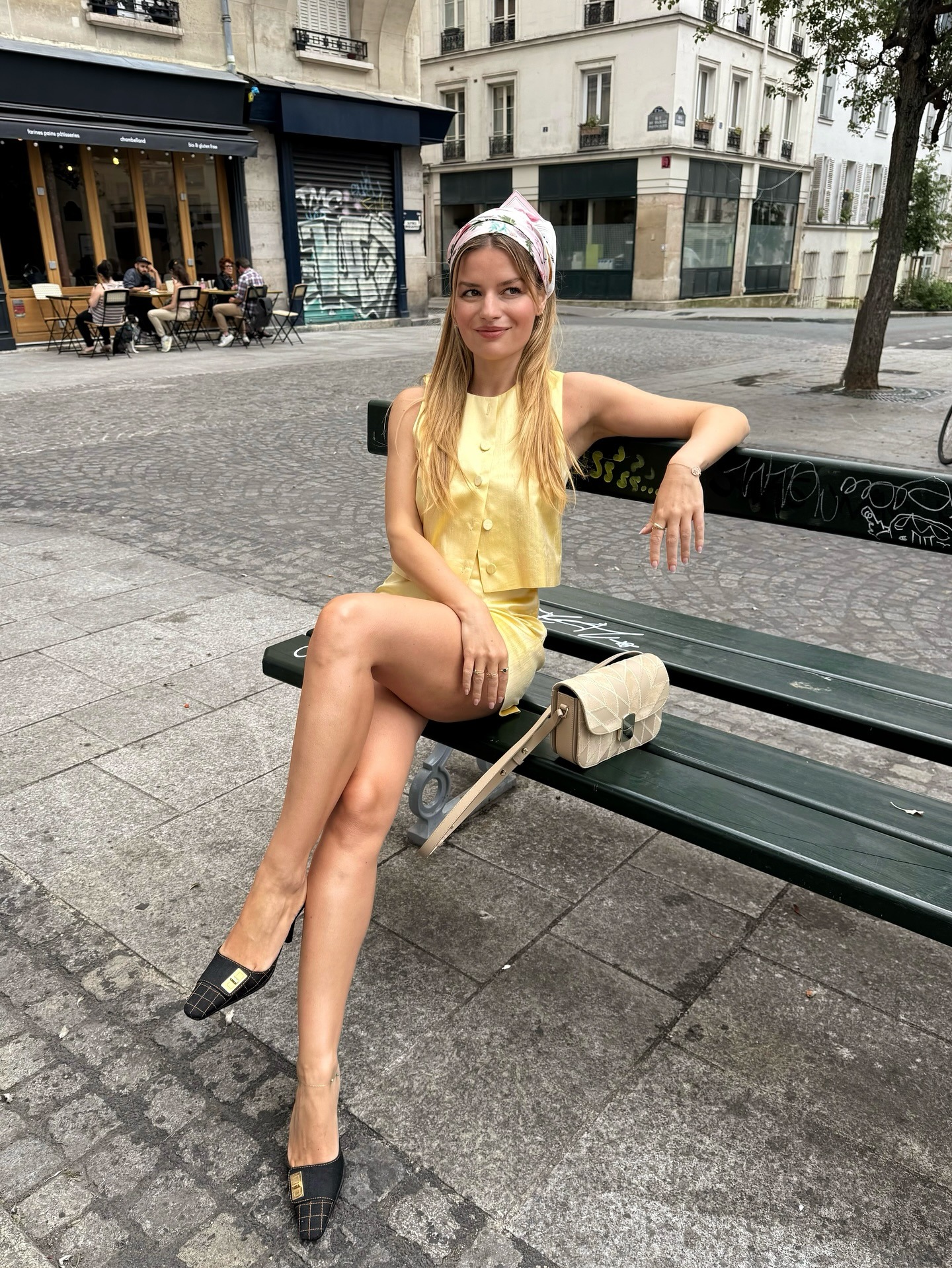 Influencer @sabinasocol wears a yellow two piece with a silk headscarf and pointed toe mules.