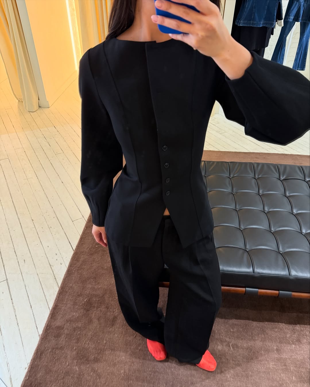 @mimixn wears red mesh flats with black trousers and a black long-sleeved waistcoat