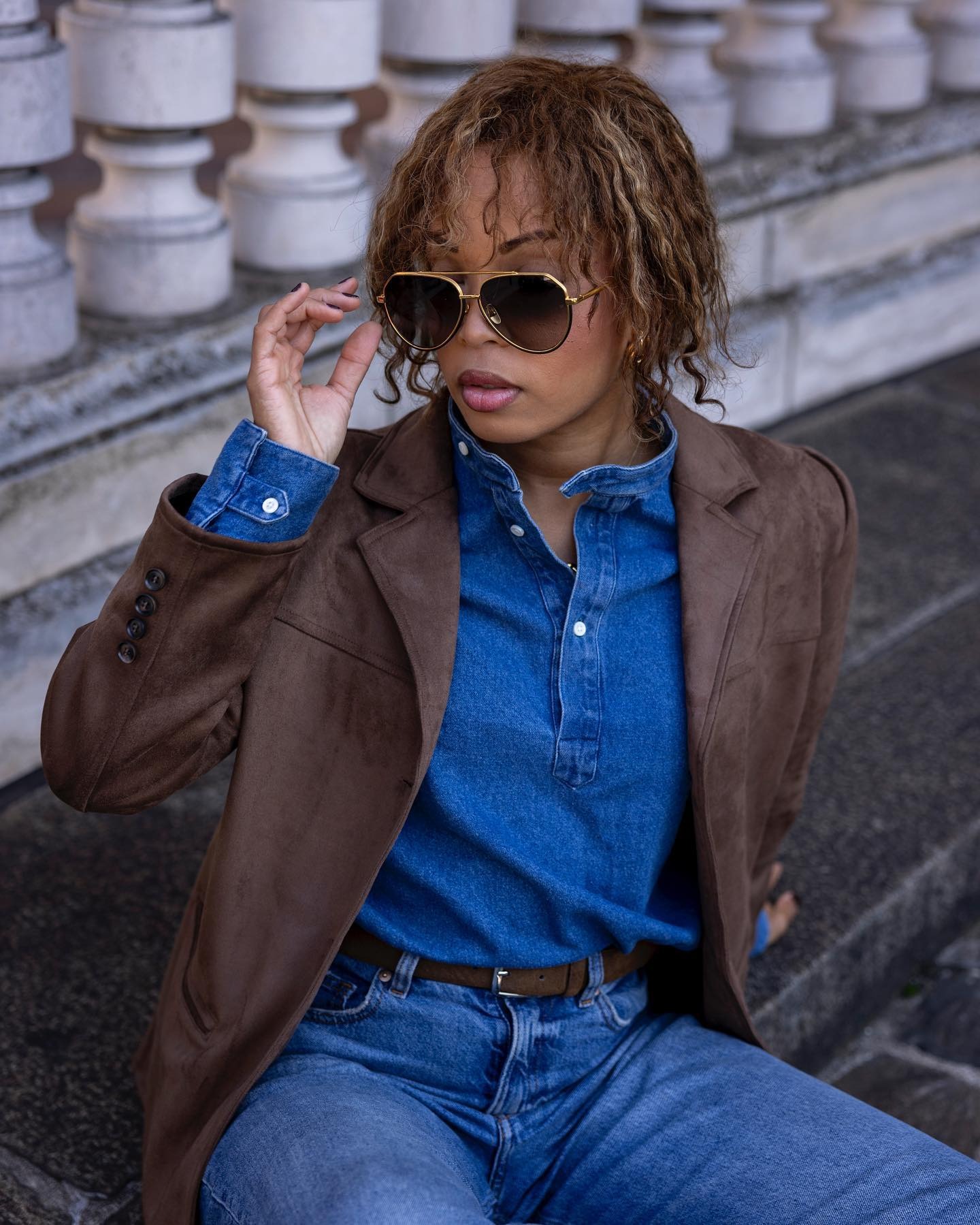 A woman with curly hair and smudged blonde highlights