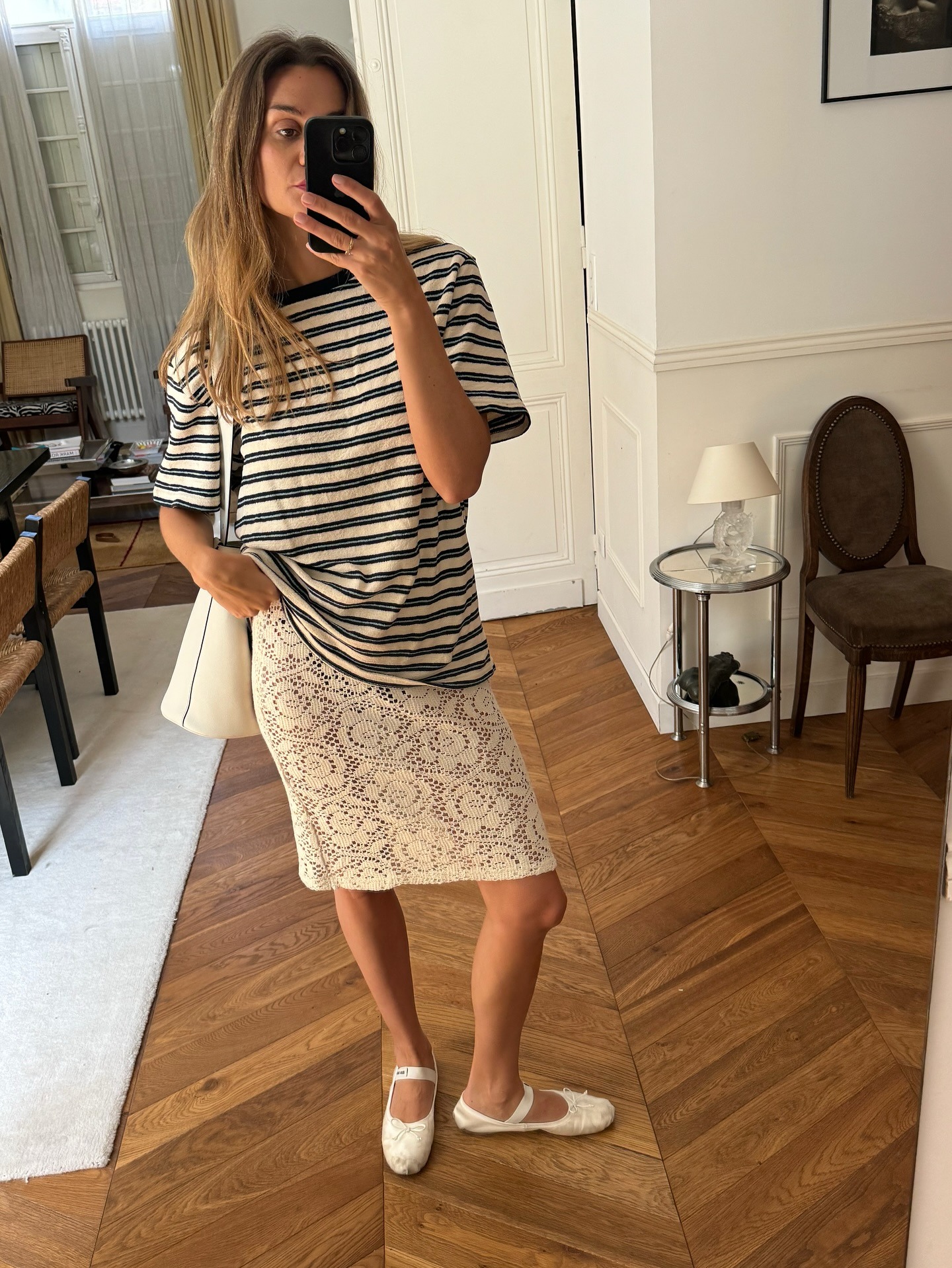 A woman wearing a stripe t shirt and a lace skirt with smudged blonde hair