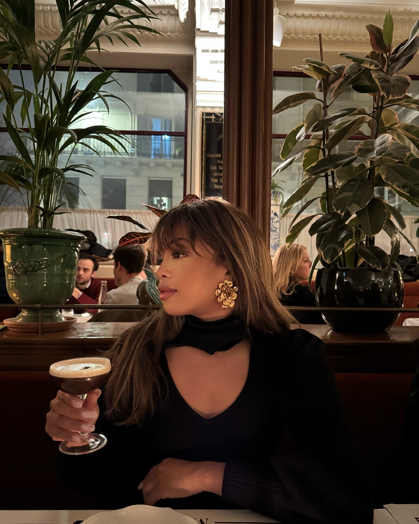 A woman in a restaurant in Paris with smudged blonde highlights