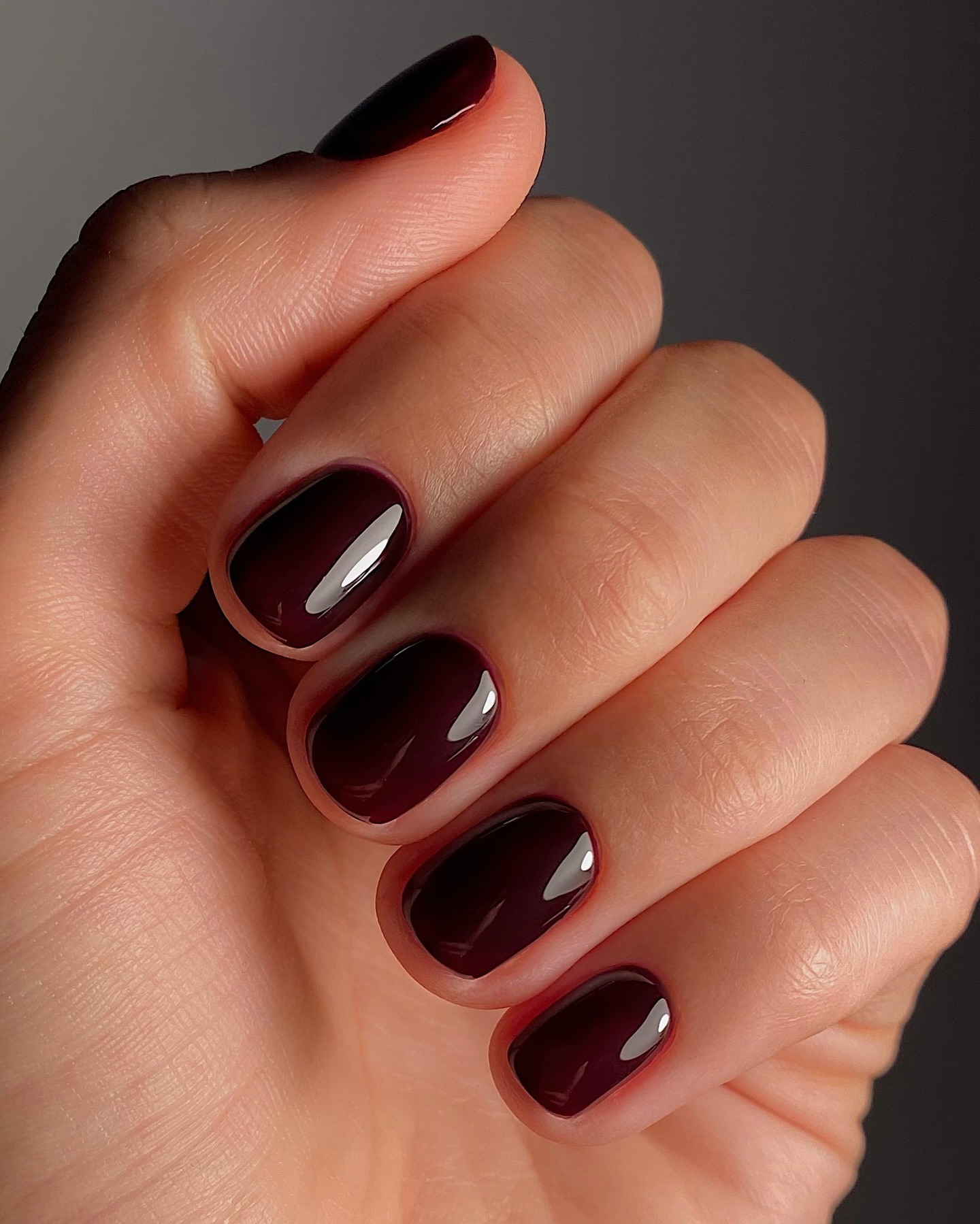 Short nails with a deep red burgundy nail colour