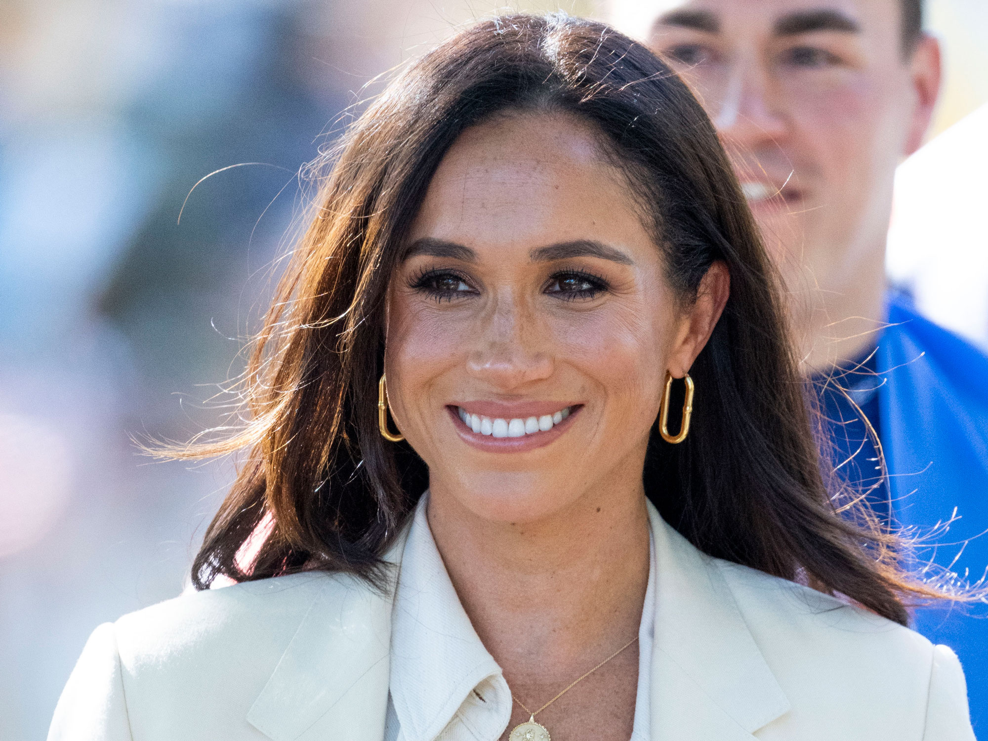Meghan Markle looks away from the camera and smiles