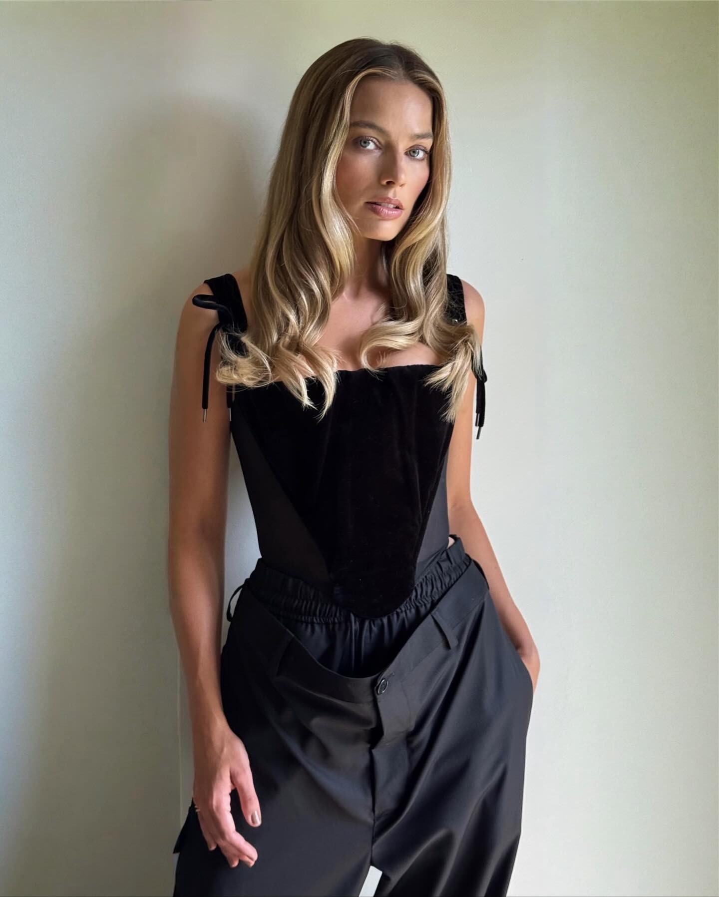 Margot Robbie wears a corset top and wide-leg trousers