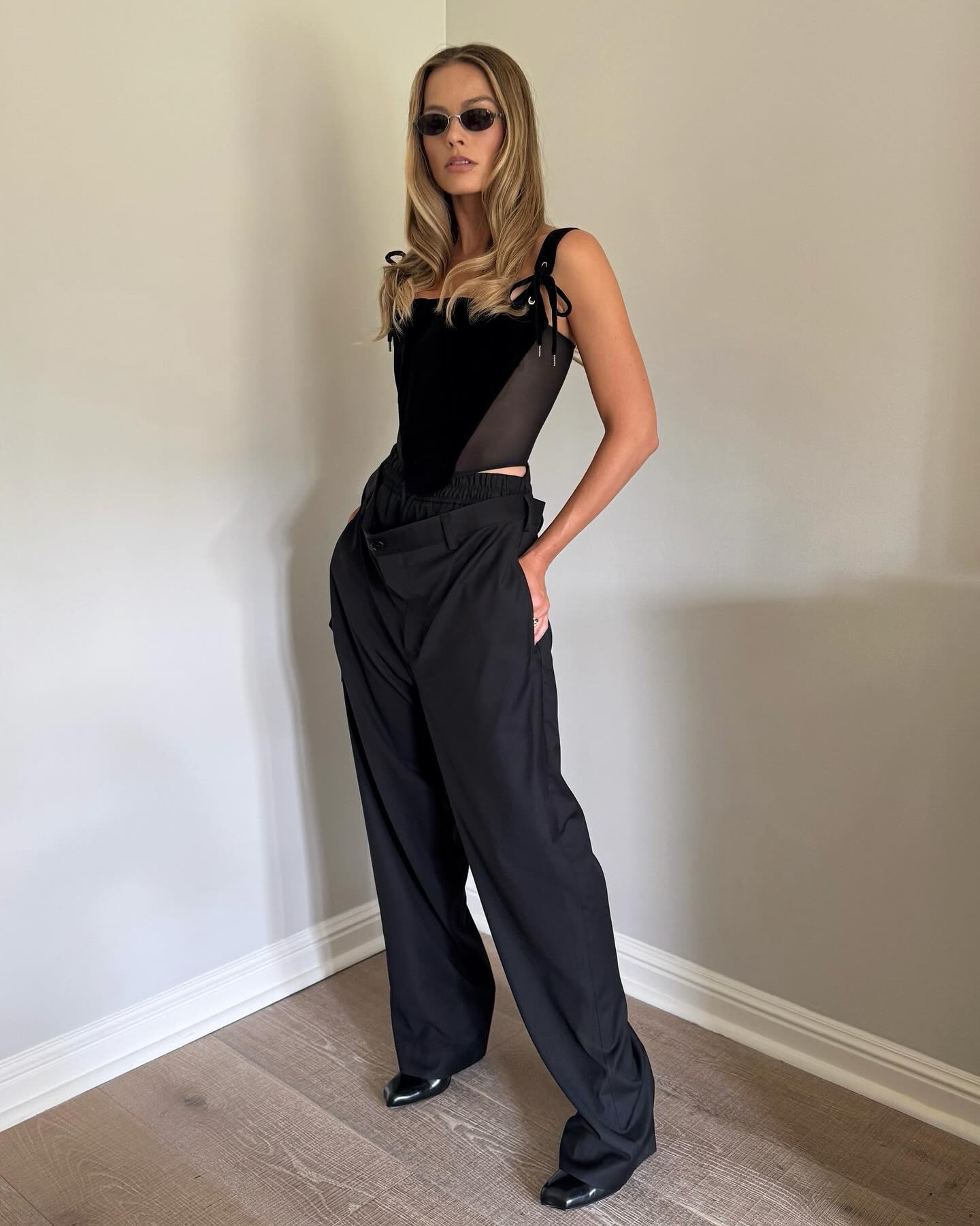 Margot Robbie wears a corset top and wide-leg trousers