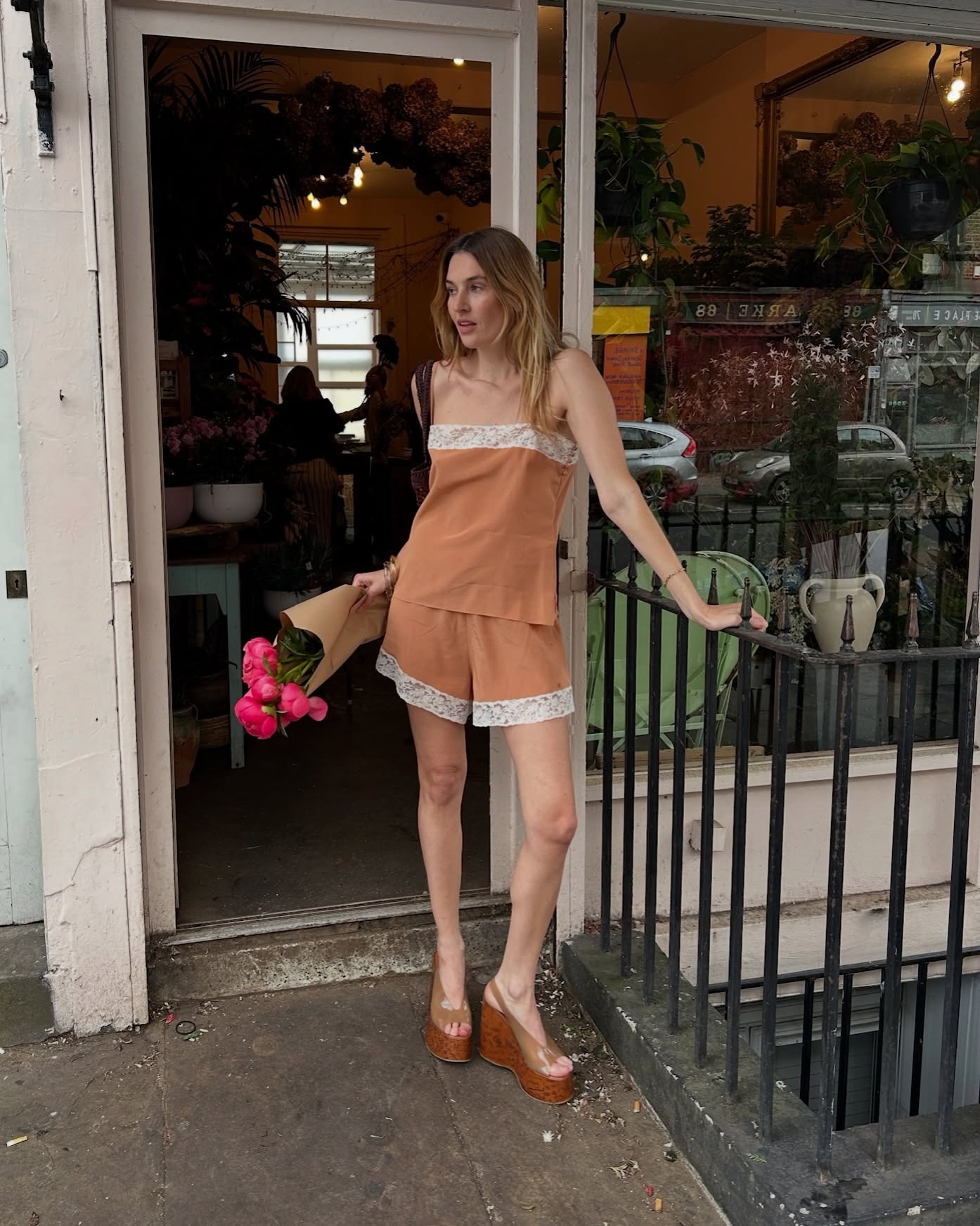 Influencer Camille wears a lace-trim short and cami set with wooden wedges.