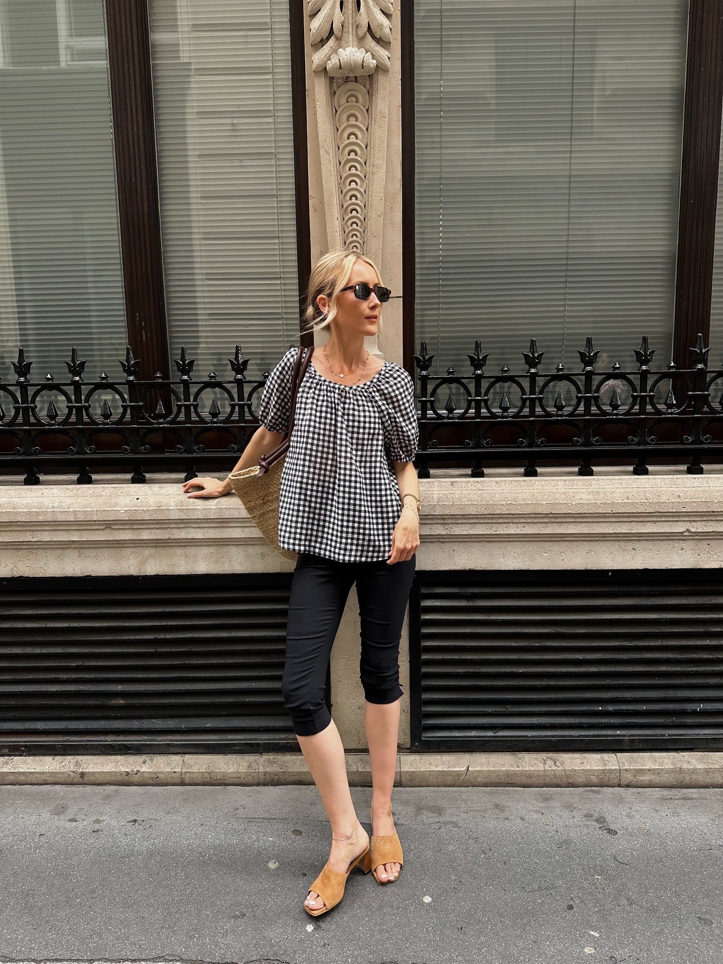 Influencer @chloekathbutler wears a short sleeve gingham blouse with capri pants and suede mule heels.