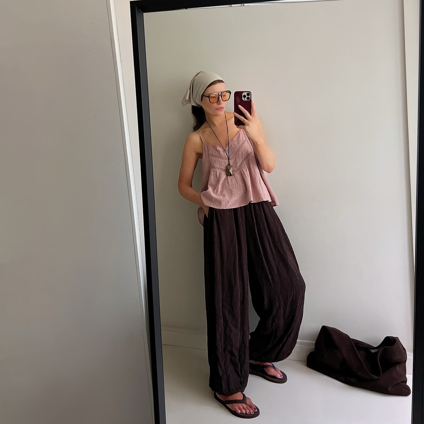 Influencer @honeybelleworld wears a pink cami top with chocolate brown sandals.