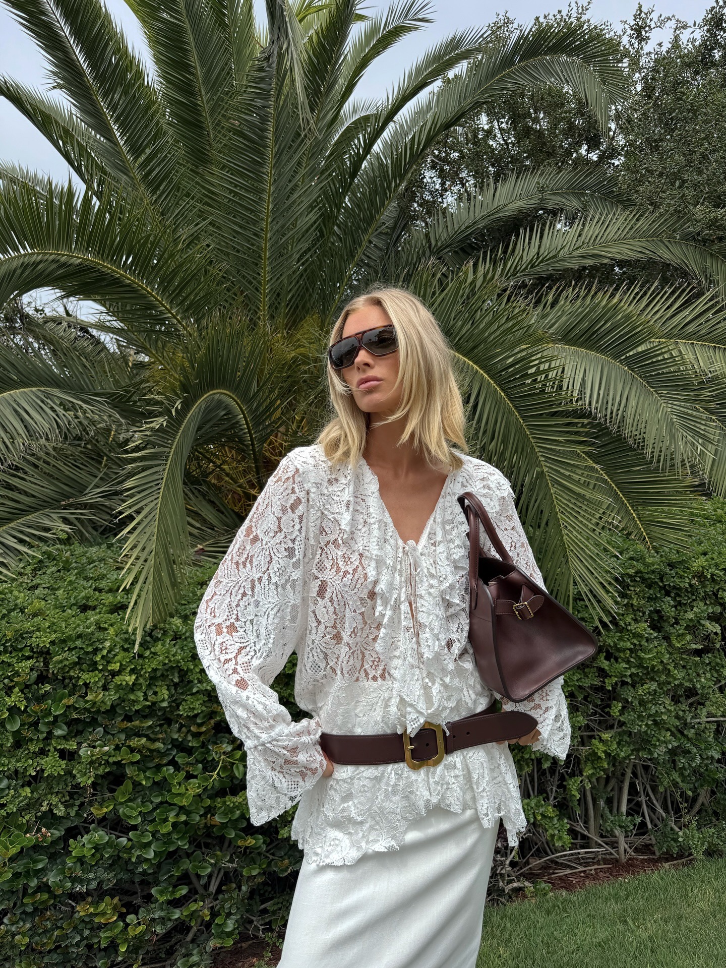 Elsa Hosk wearing a white lace ruffled blouse and white maxi skirt