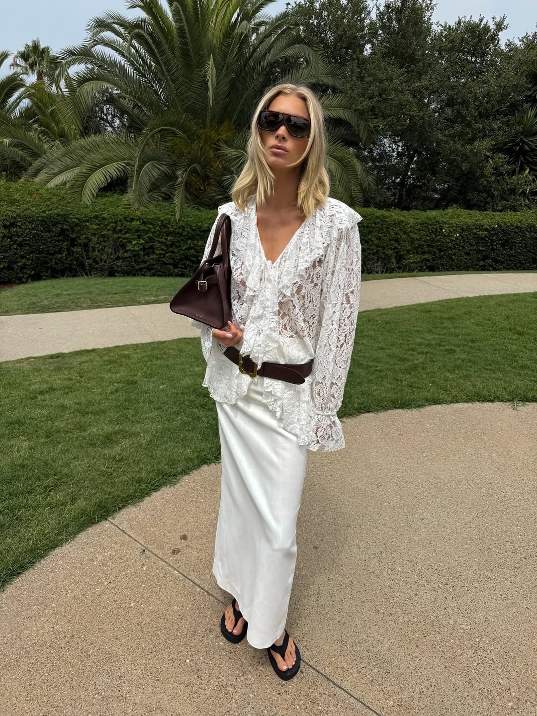 Elsa Hosk wearing a white lace ruffled blouse and white maxi skirt