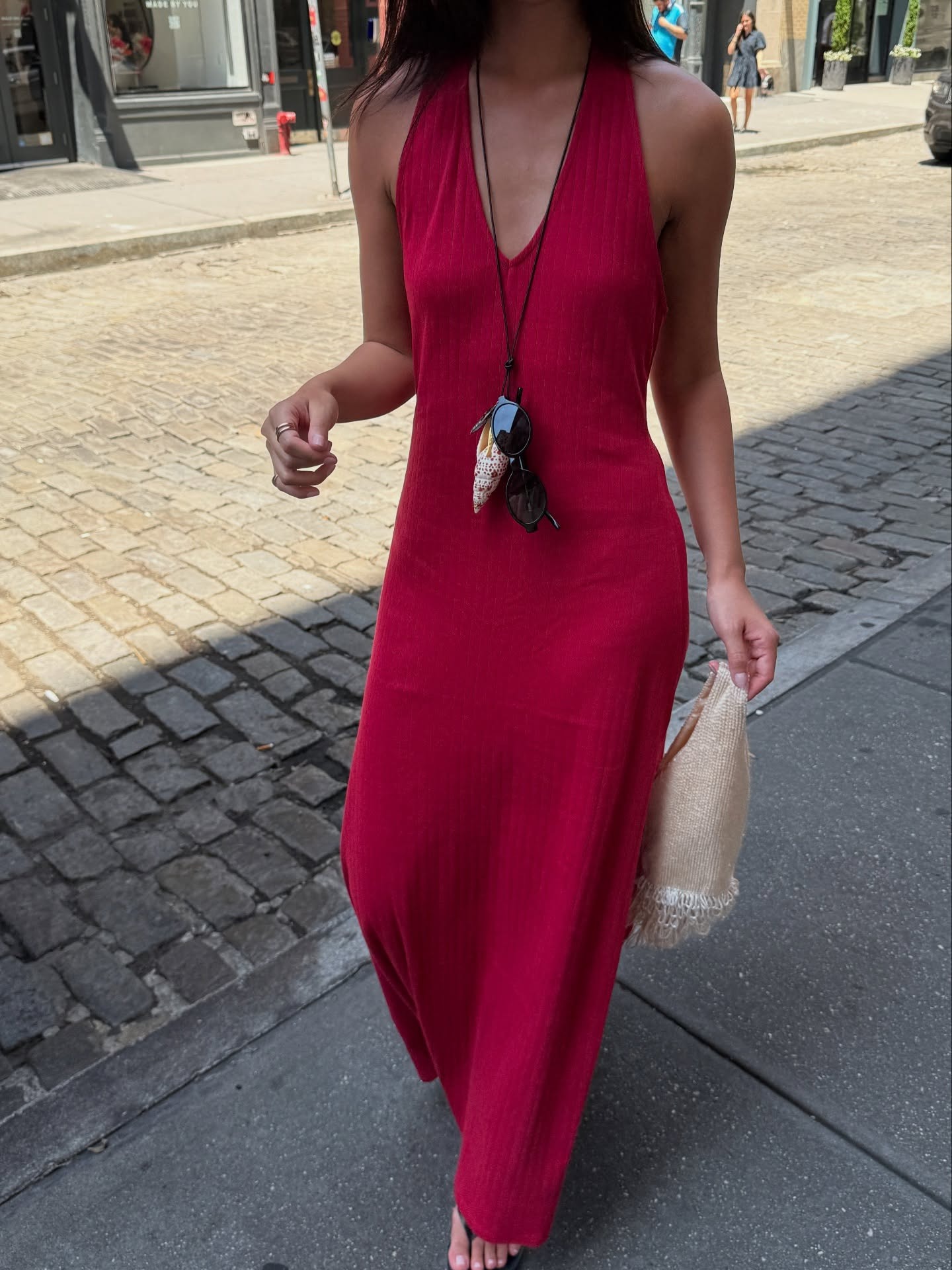 @mimixn wearing a red V-neck dress and long cord necklace.