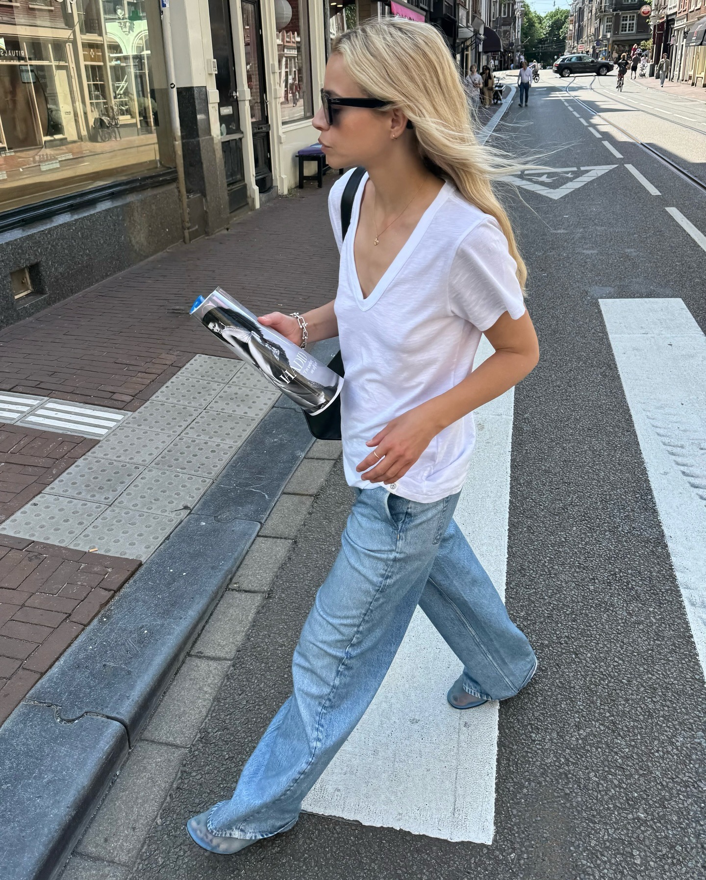 @stephaniebroek wearing a white V-neck T-shirt with jeans.