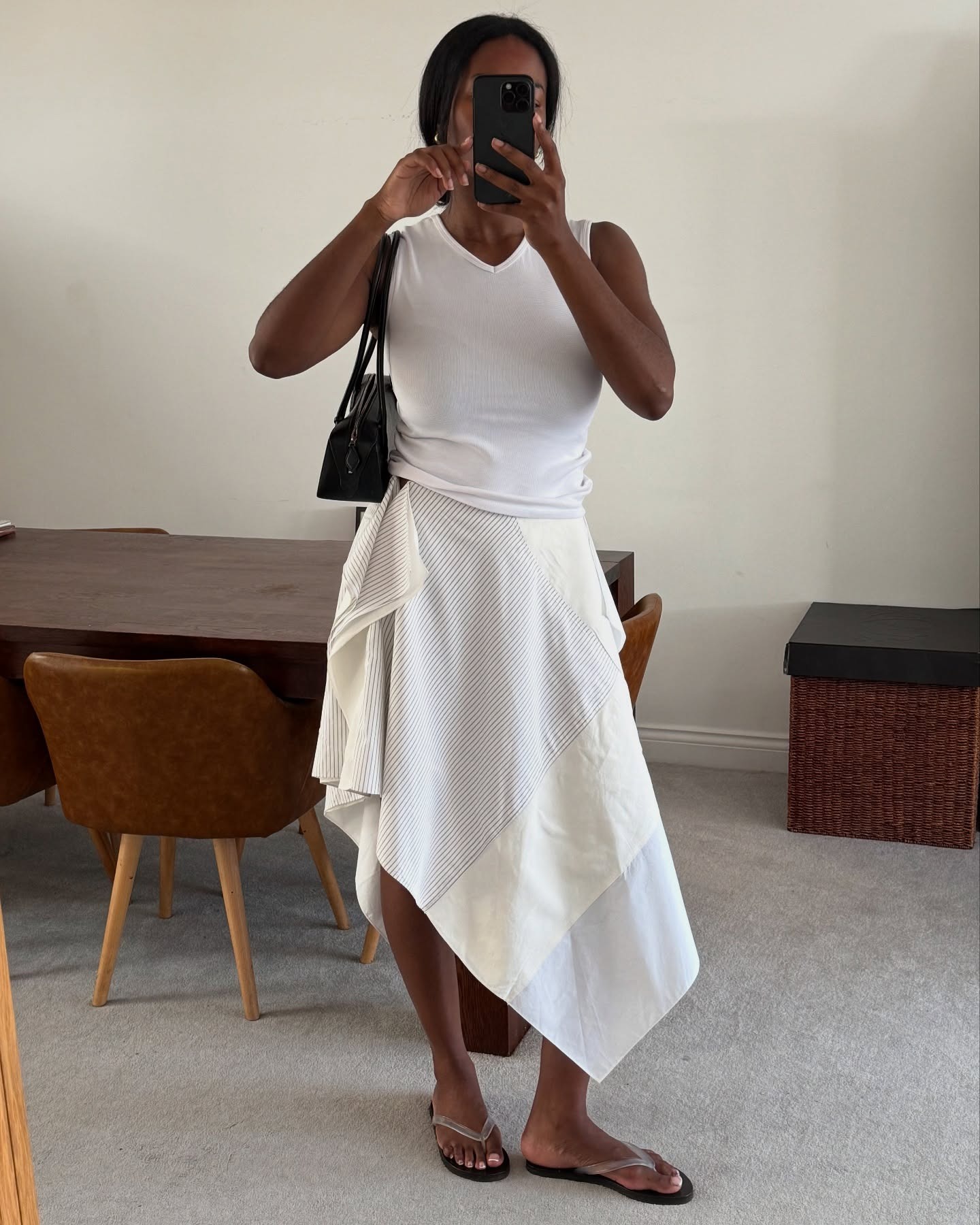 @nlmarilyn wearing a V-neck white tank top with a poplin skirt.