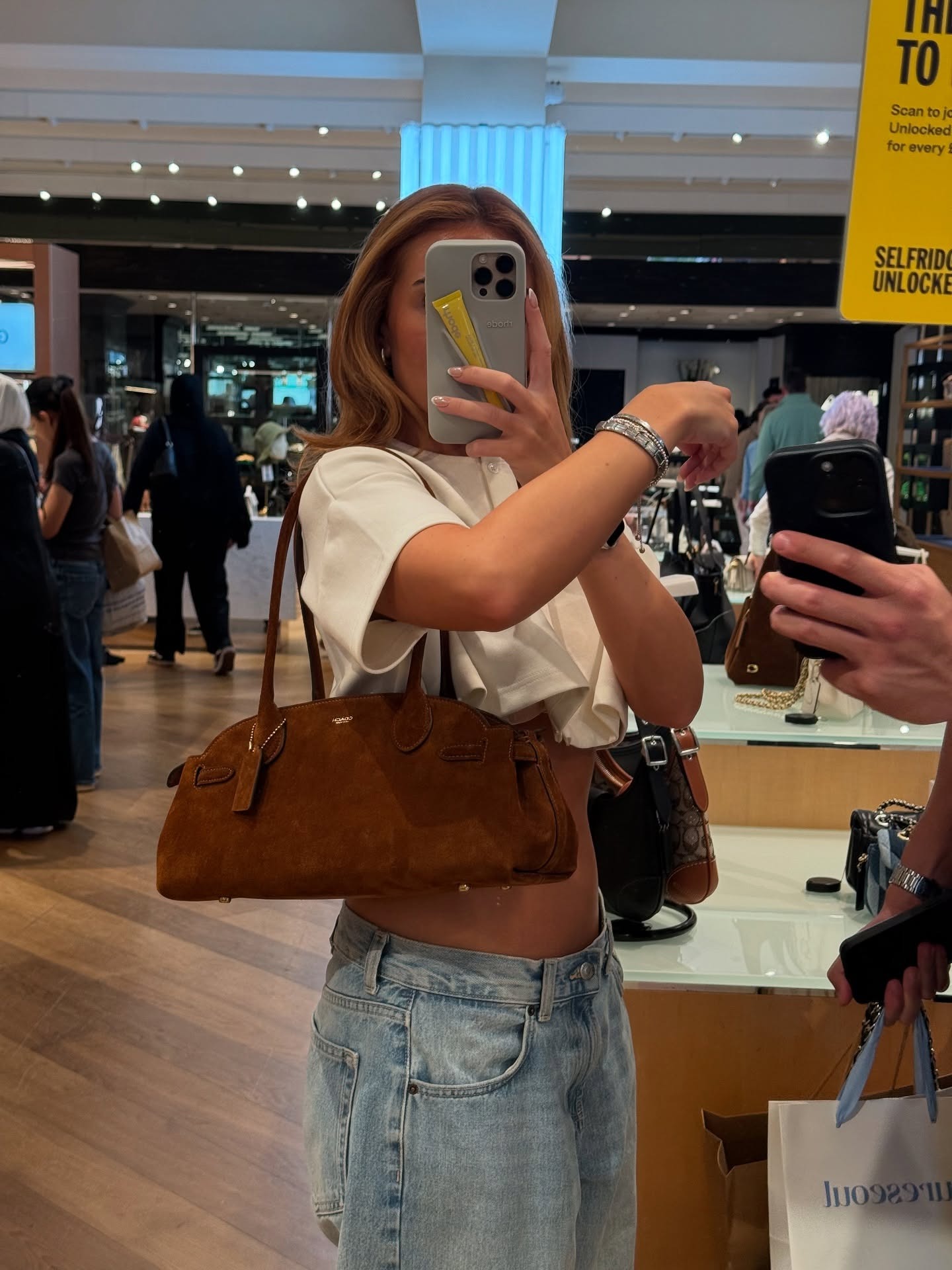 Fashion person Sophie wears the Coach Empire carryall 34. She pairs it with baggy jeans and a white cropped tee in a recent image from her Instagram.