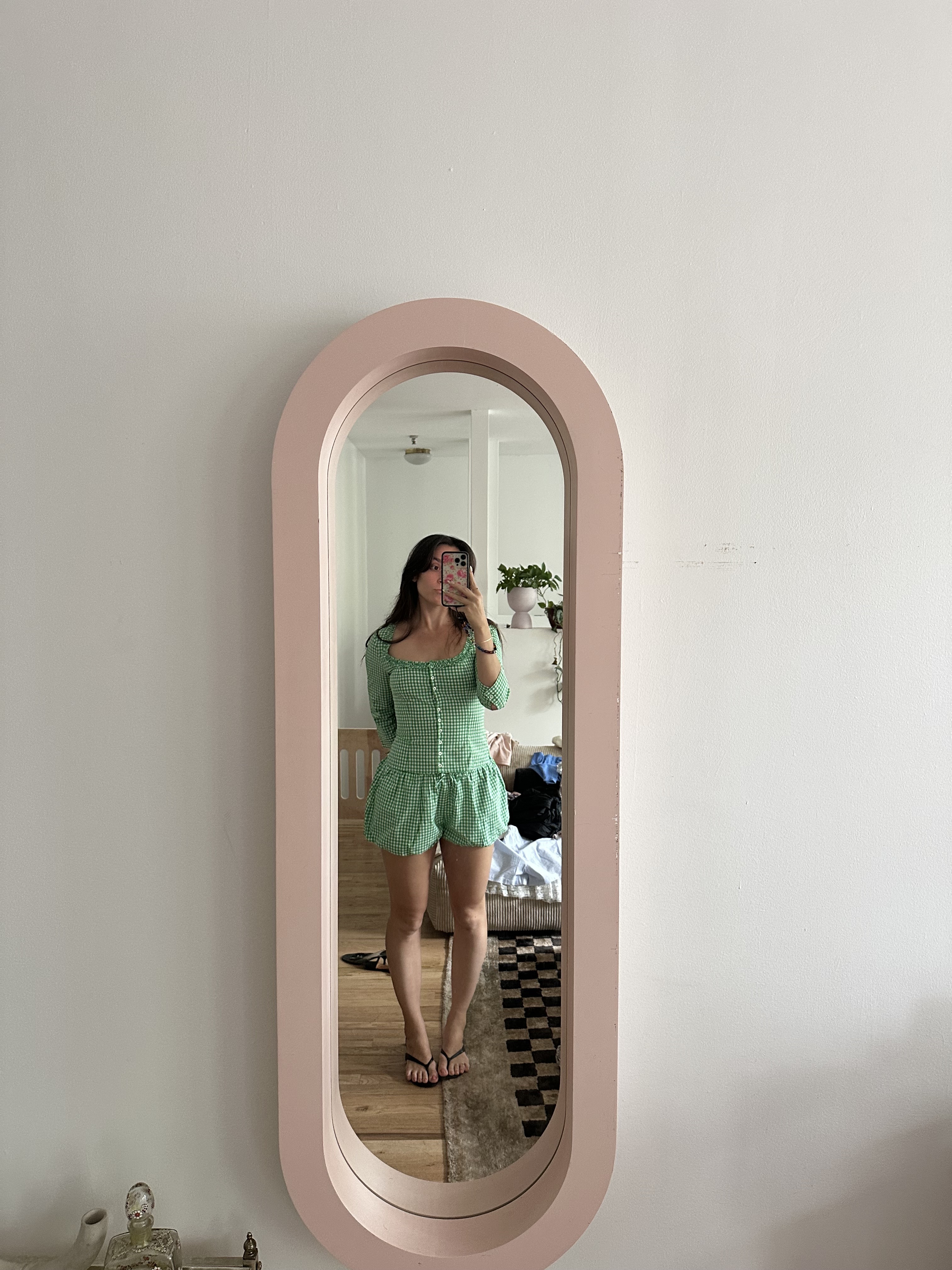 Tara Gonzalez wearing a Sandy Liang gingham set while taking a mirror selfie.