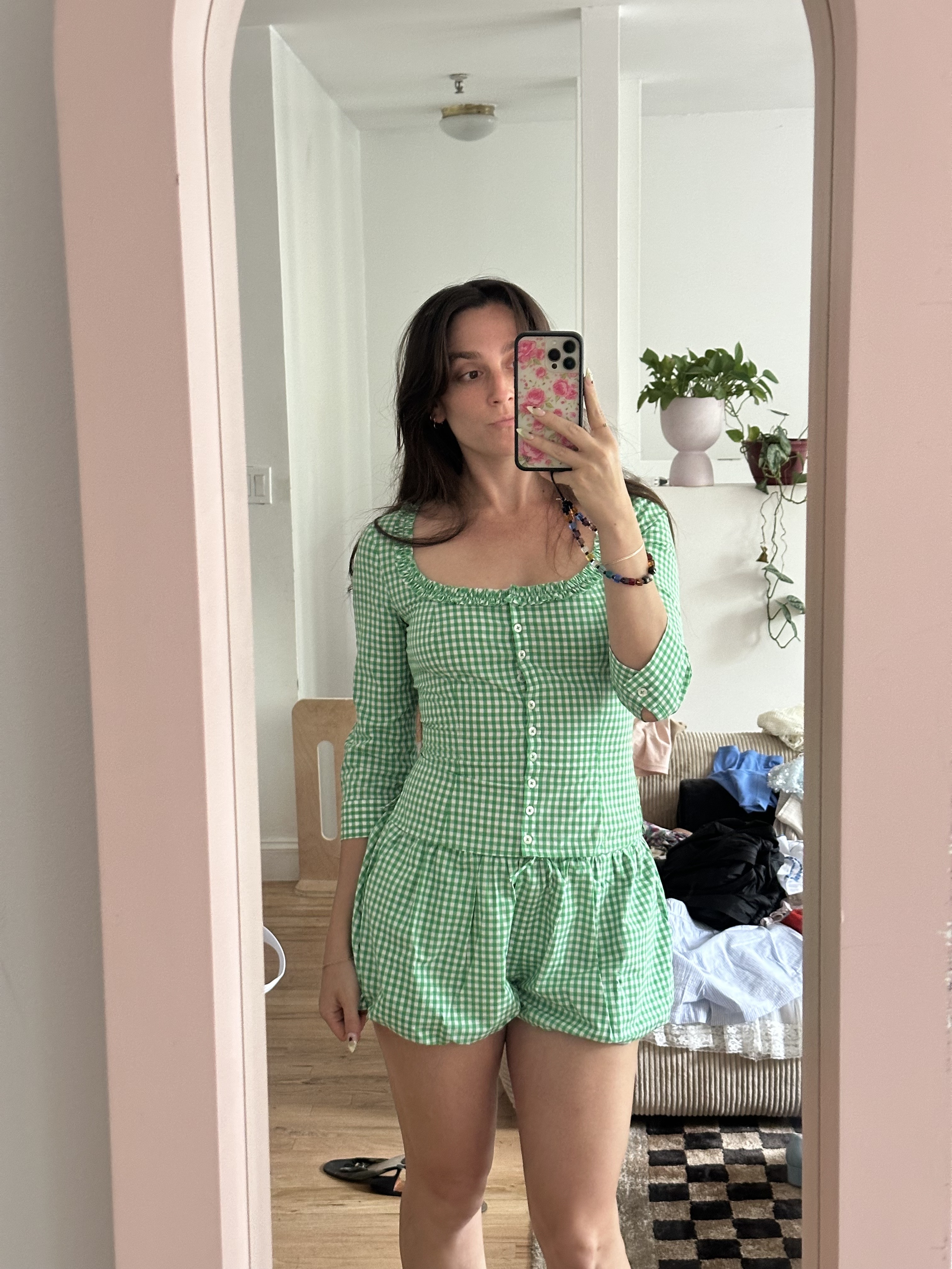 Tara Gonzalez wearing a Sandy Liang gingham set while taking a mirror selfie.