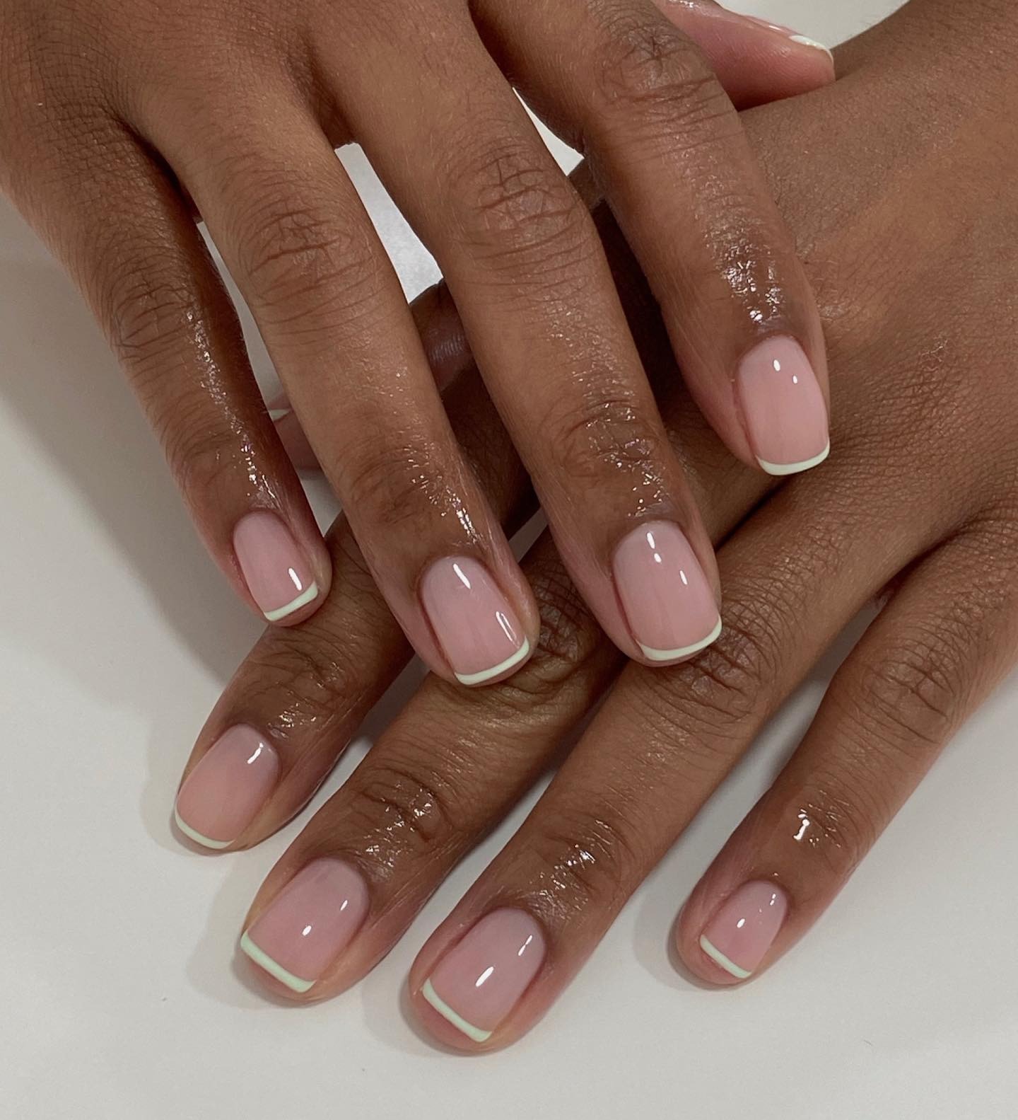 A short, square, super glossy French manicure