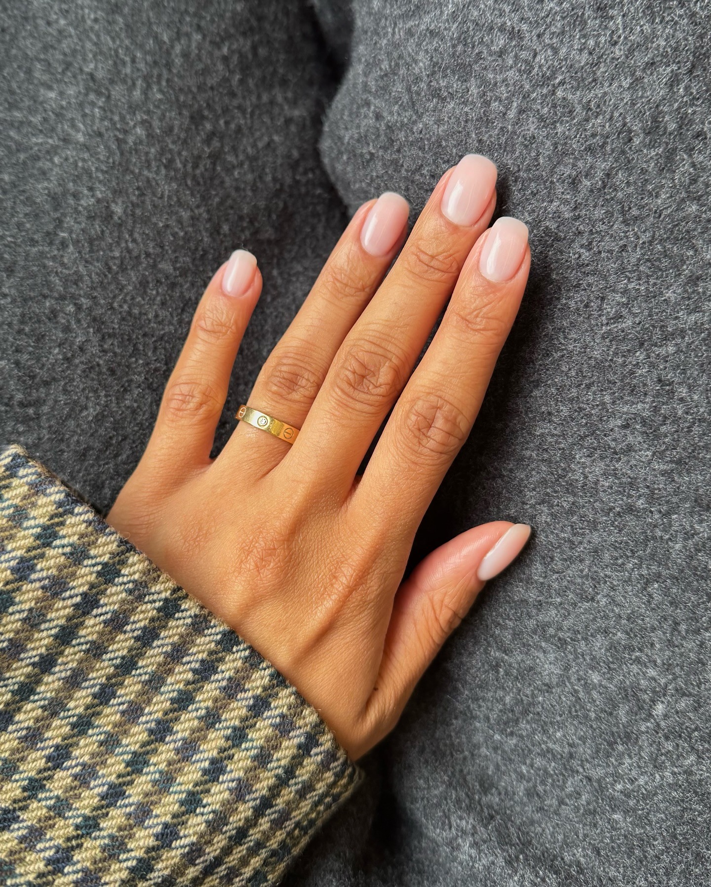 Short, square nails with a milky, shimmery nail polish