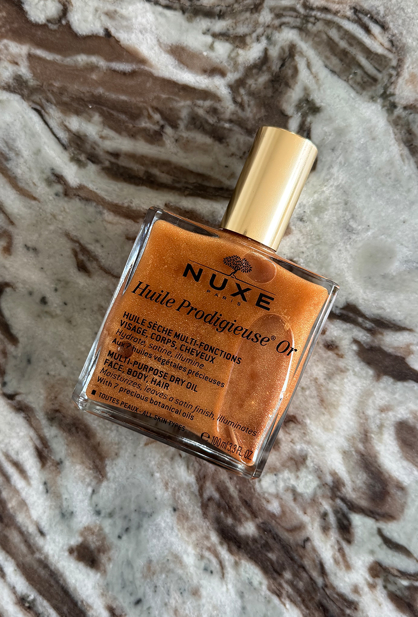 Nuxe Huile Prodigieuse Or shimmer body oil on marble table