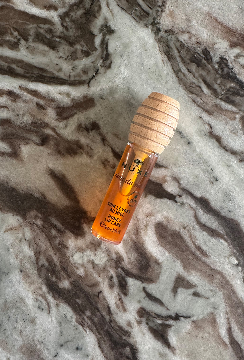Nuxe Honey Lip Oil on marble table