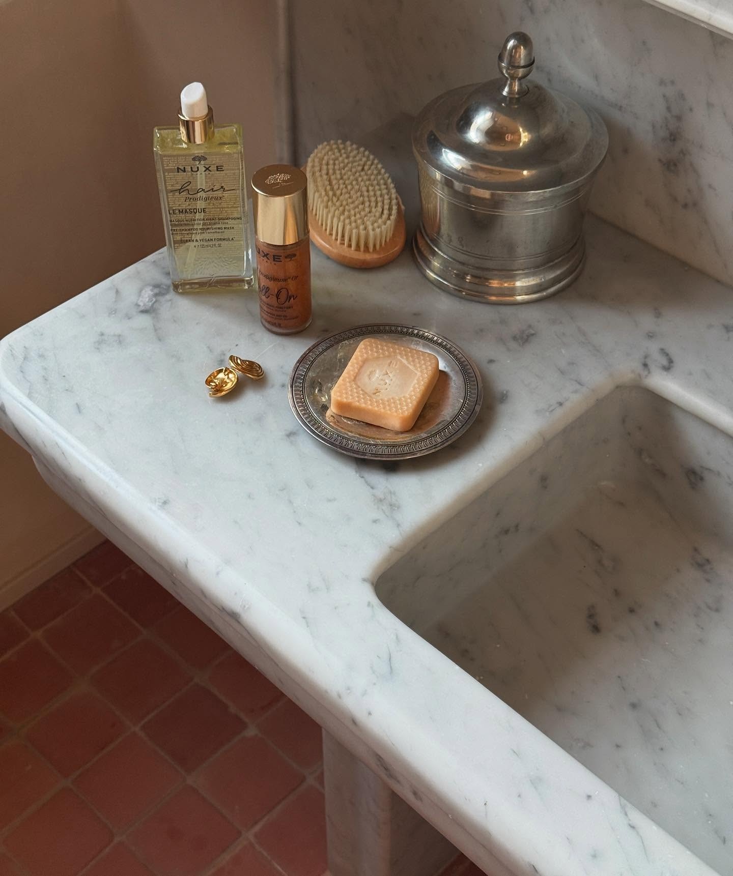 Marble sink with Nuxe products on the side
