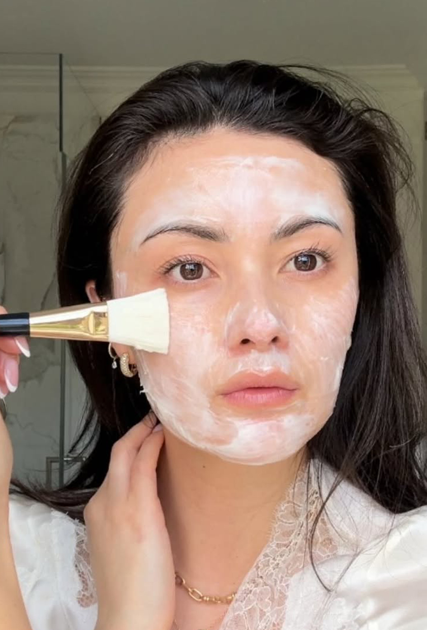 Peony Lim applying a face mask to her skin with a brush
