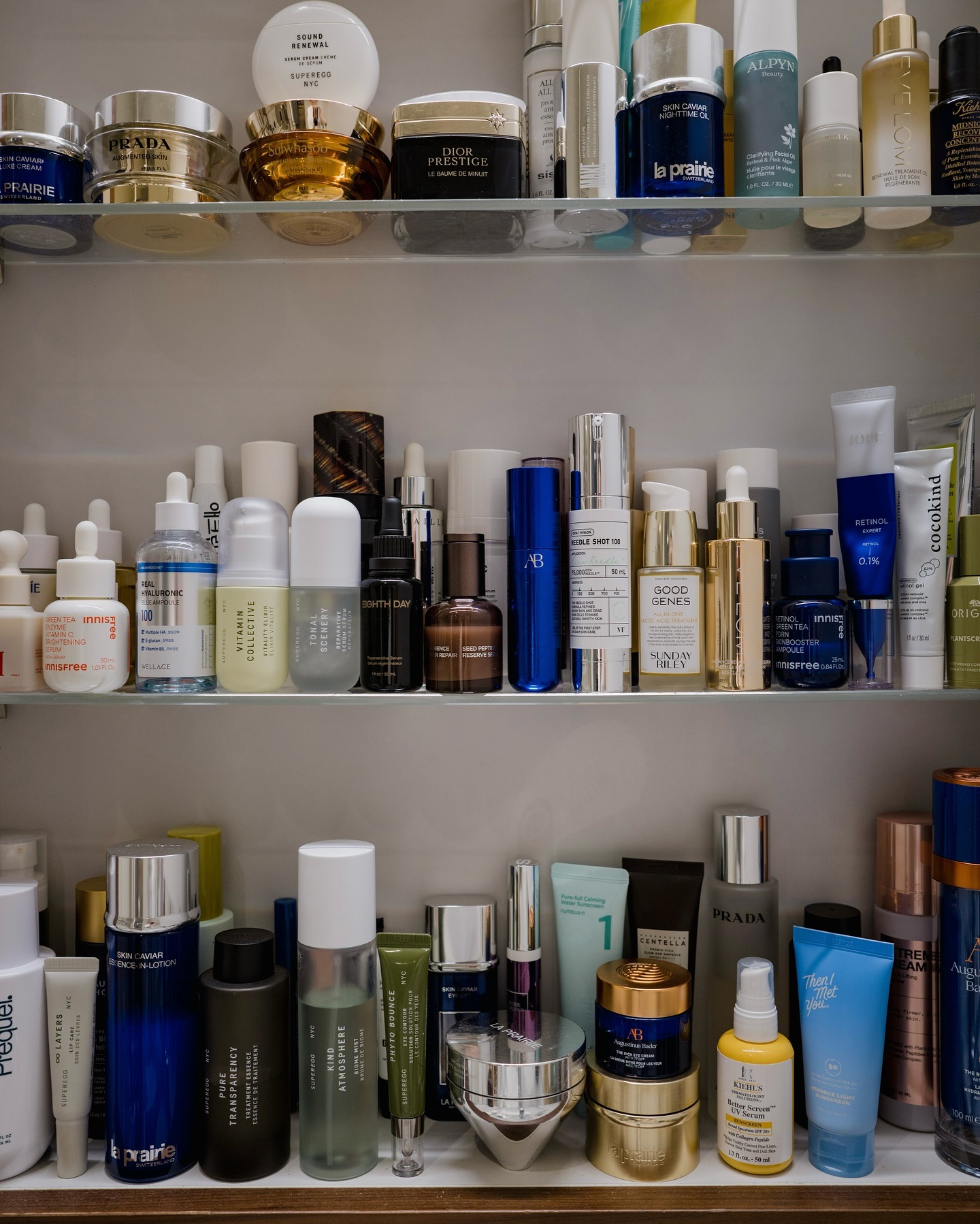 A photo of a bathroom shelf filled with skincare products including serums and cleansers