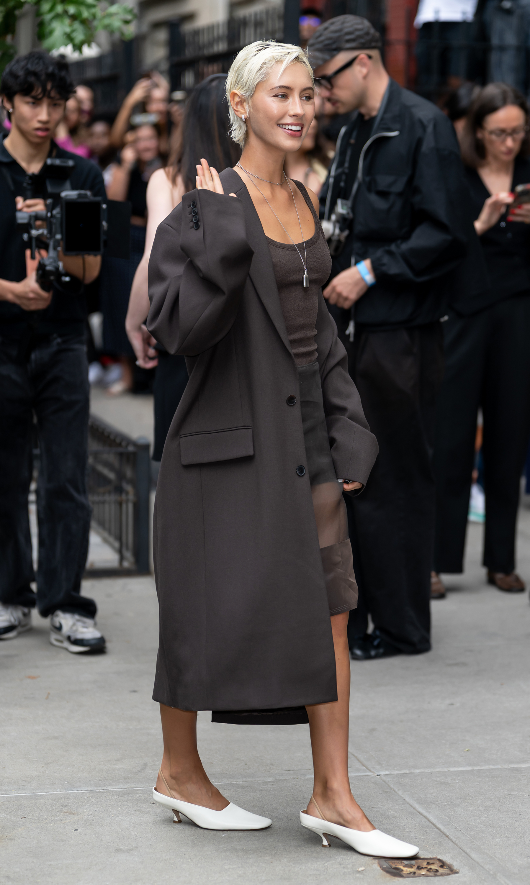 Iris Law walks into a fashion show wearing an all-brown outfit.