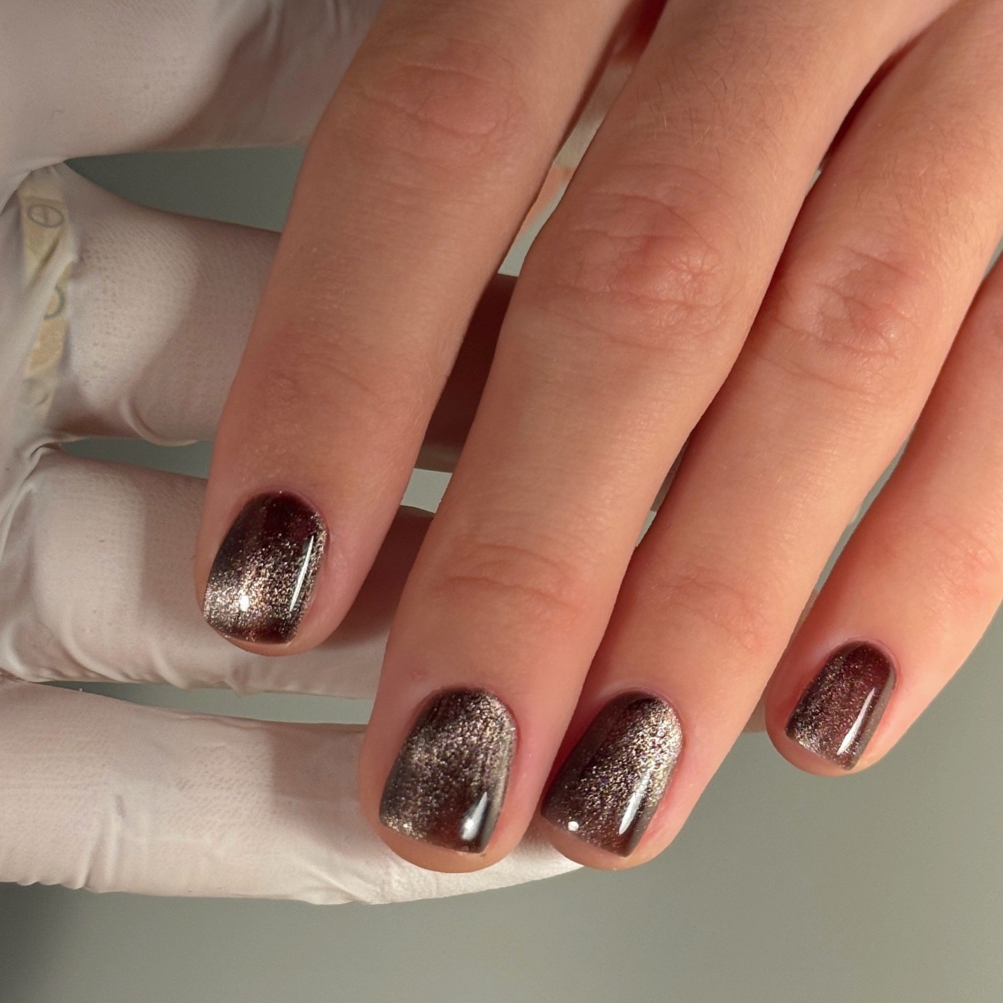 A chocolate brown cat eye nail design