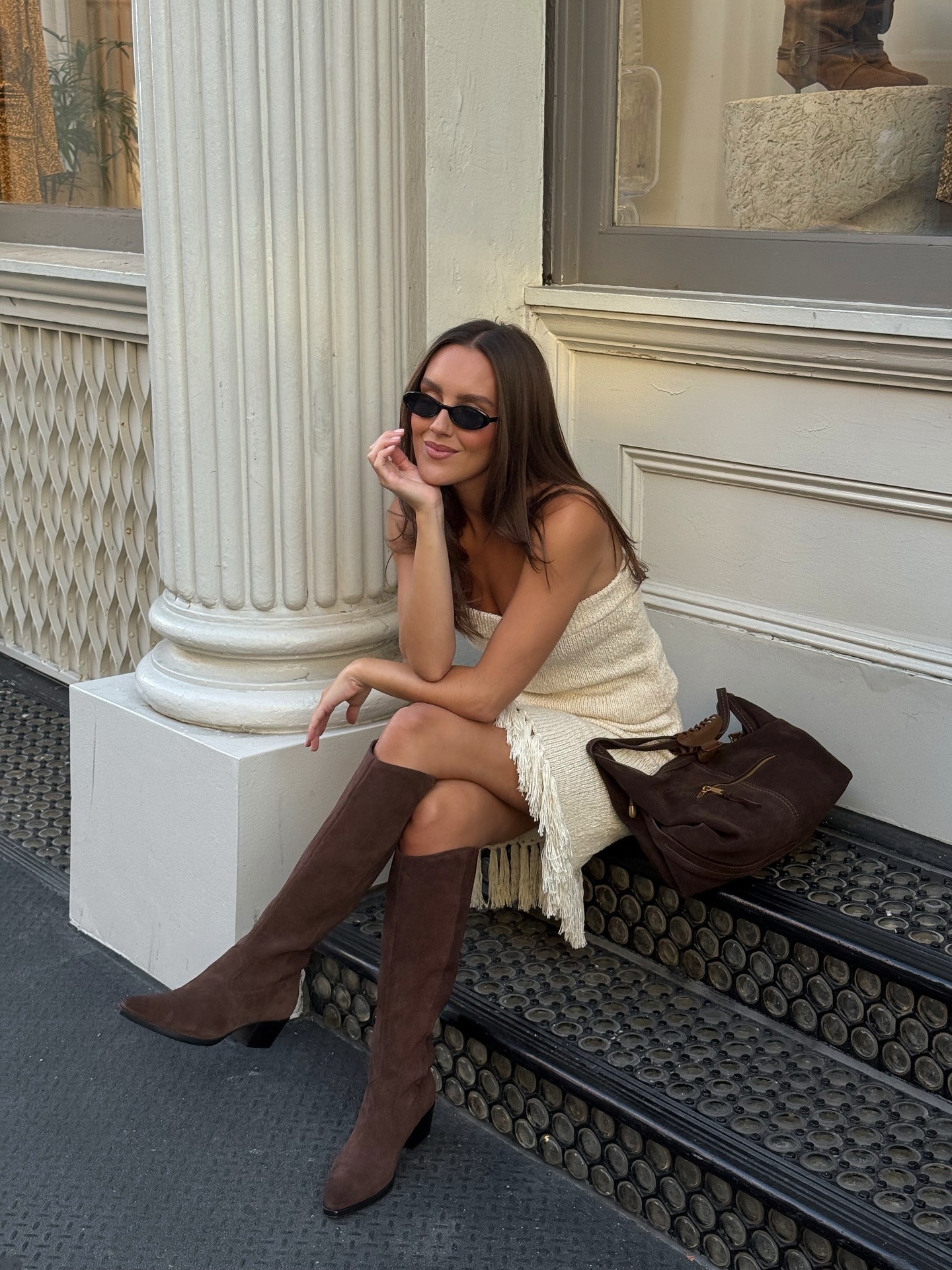 Influencer @emmaleger wears brown knee high boots with a knitted two-piece and brown suede bag.