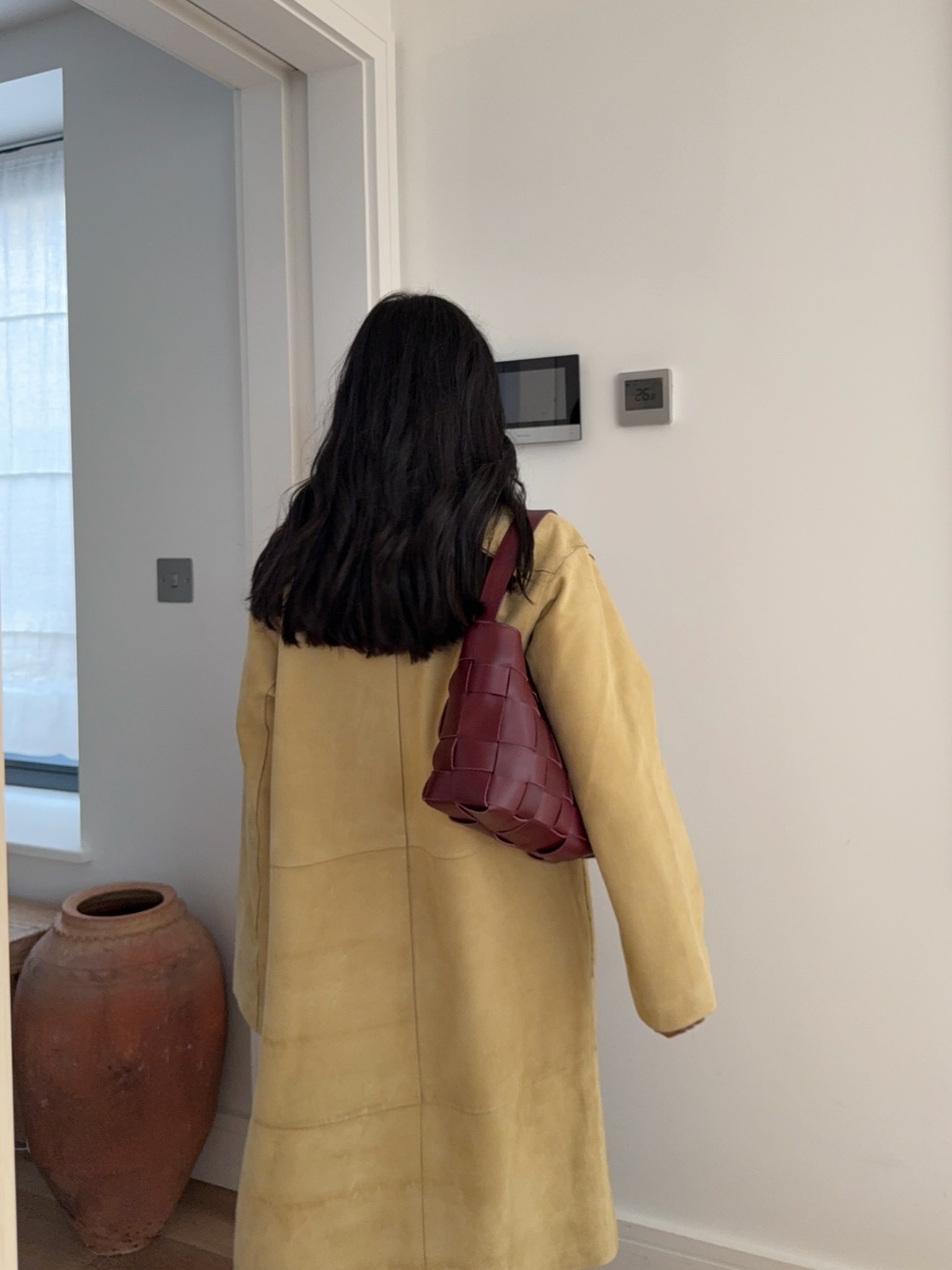 Influencer @monikh wears a butter yellow boat with a burgundy handbag.