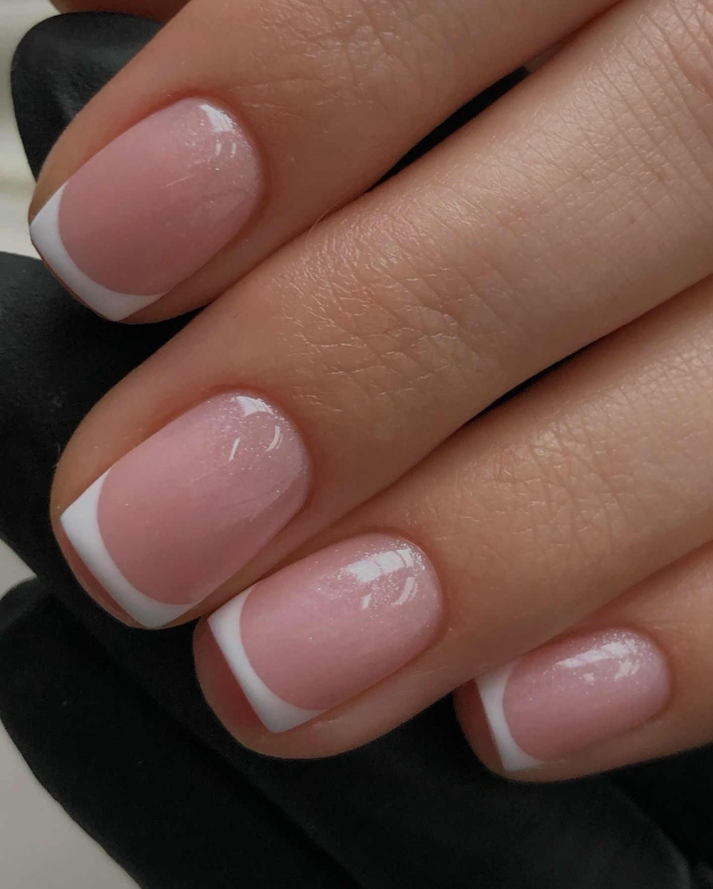 A close-up shot of a classic French manicure