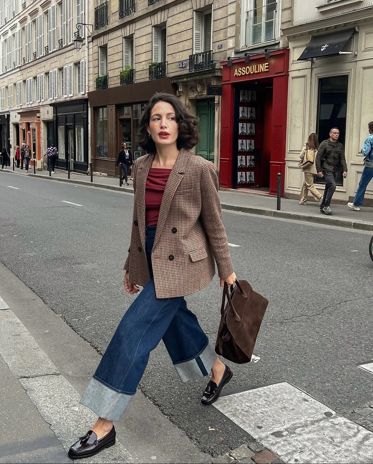 Influencer @melodiebanfield walks across the street in Paris wearing a red blazer, red top, cropped jeans and glossy leather loafers.