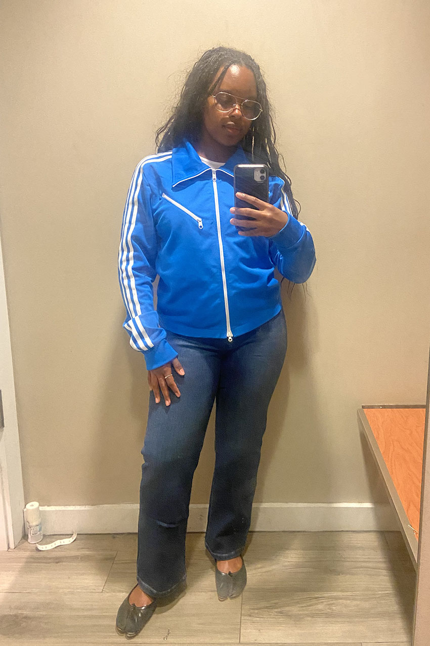 A woman wearing a blue jacket and bootcut jeans