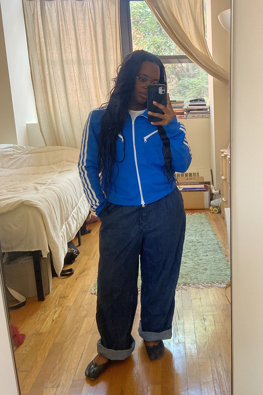 A woman wearing a blue jacket and baggy jeans