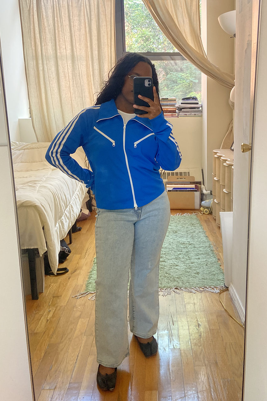 A woman wearing a blue jacket and light wash skinny jeans