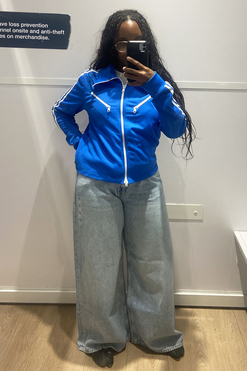 A woman wearing a blue jacket and baggy jeans