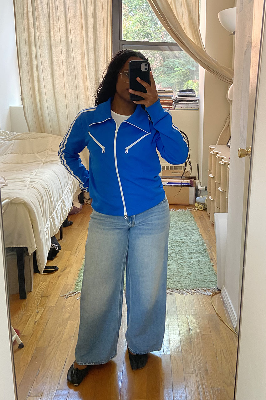 A woman wearing a black jacket and wide-leg jeans