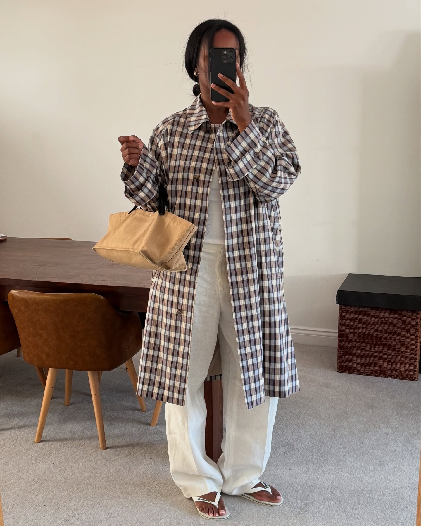 Marilyn wears a plaid jacket, white jeans, white flip-flops, and a brown bag.