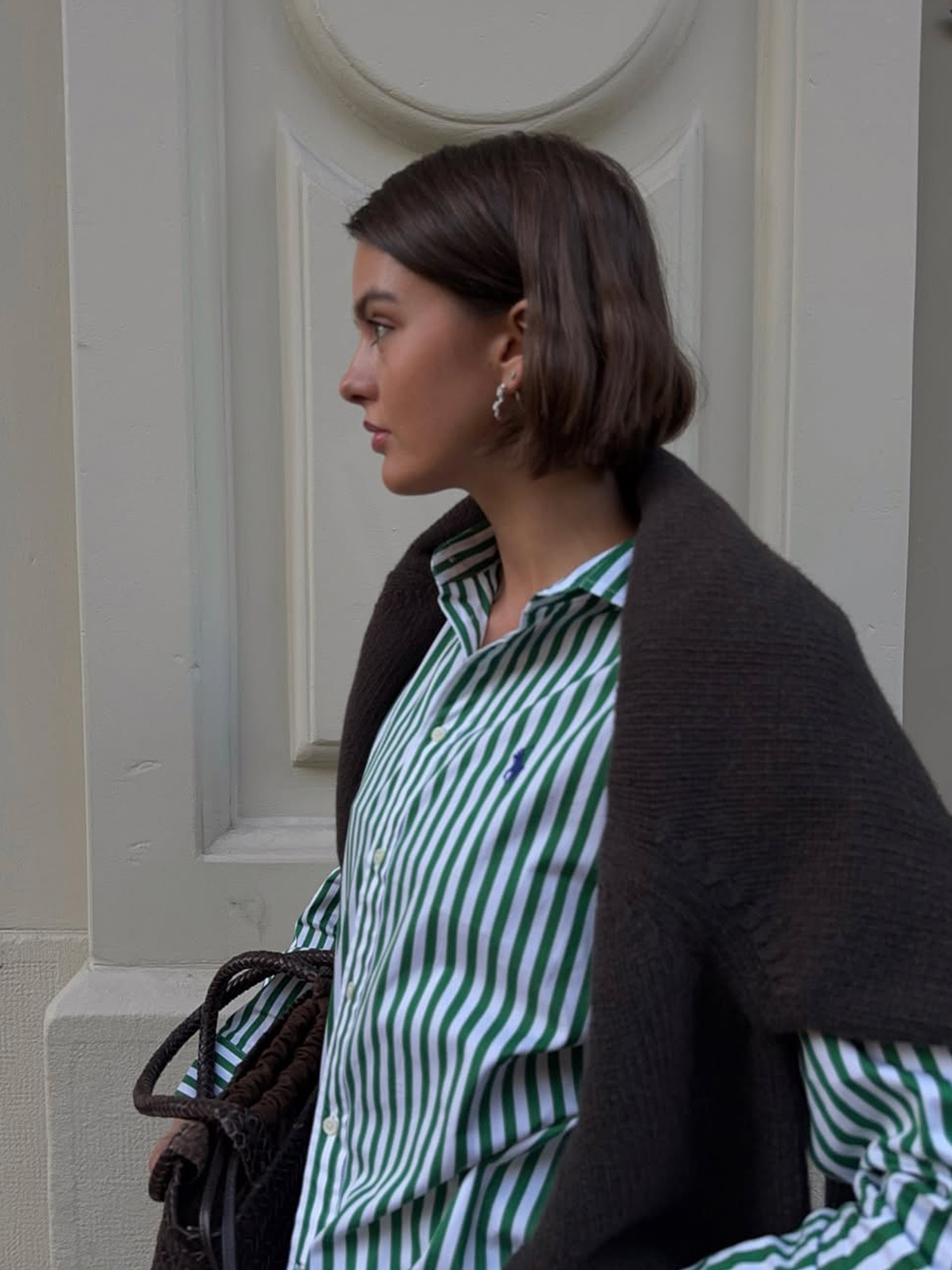 Mary L. Jean wears a coiffed bob with a striped button-up shirt and chocolate brown sweater.
