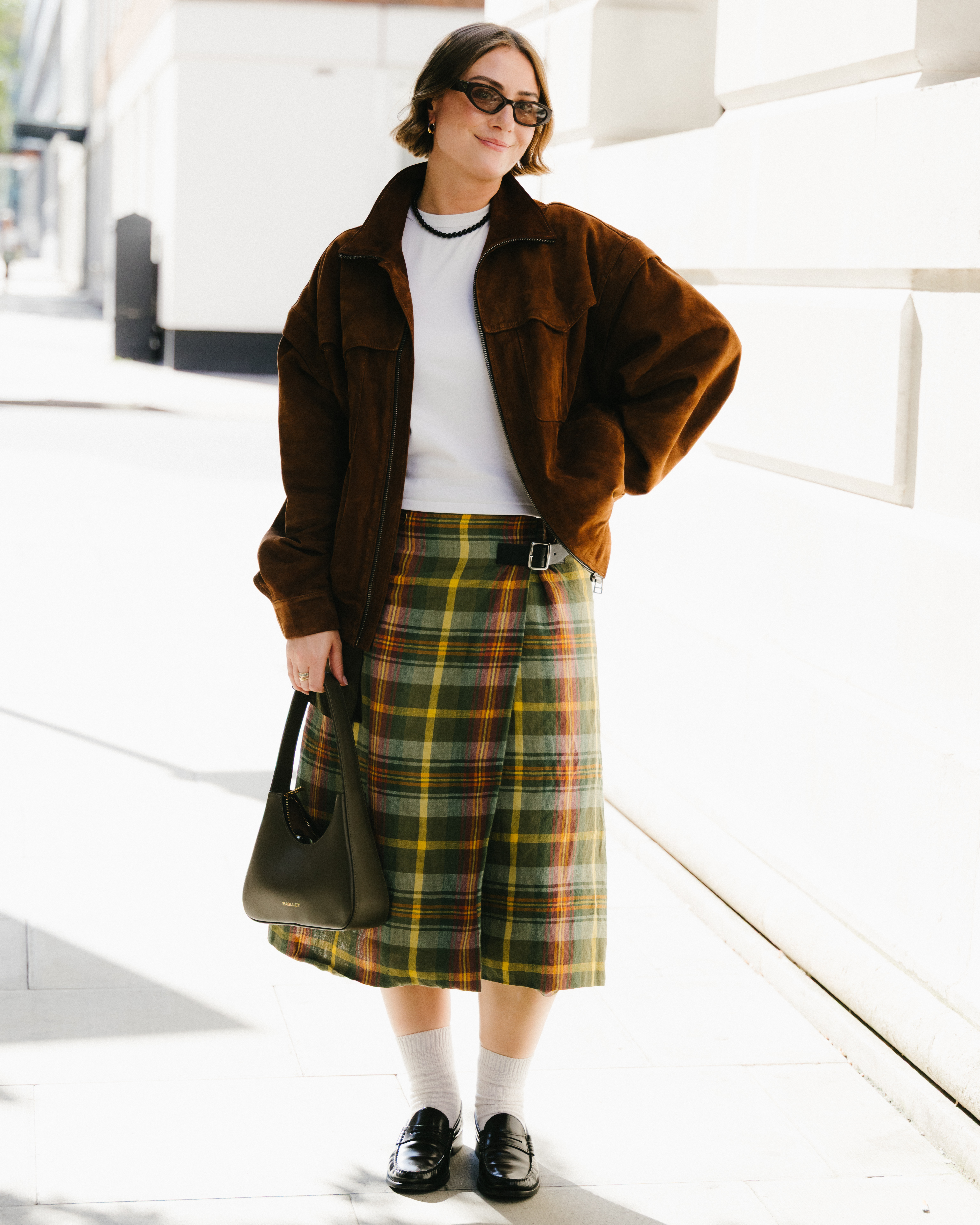 London Fashion Week attendees wears midi skirts with socks and loafers.